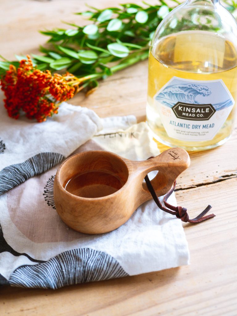 Serving mead from a wooden cup