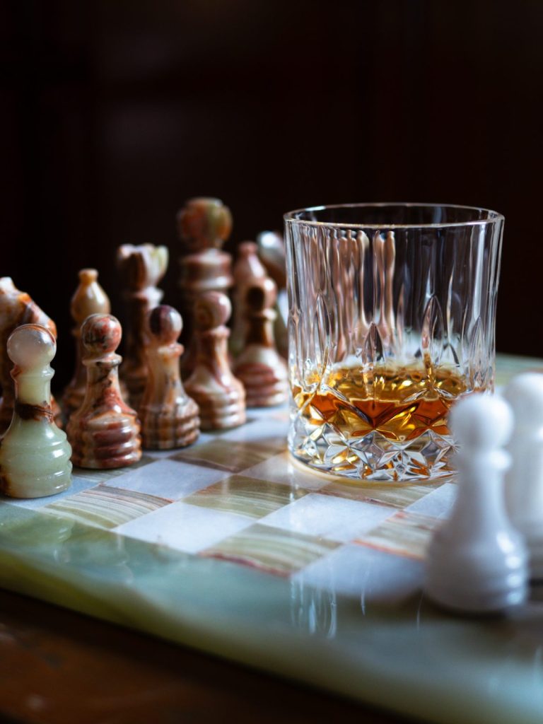 whisky glass on a chess board