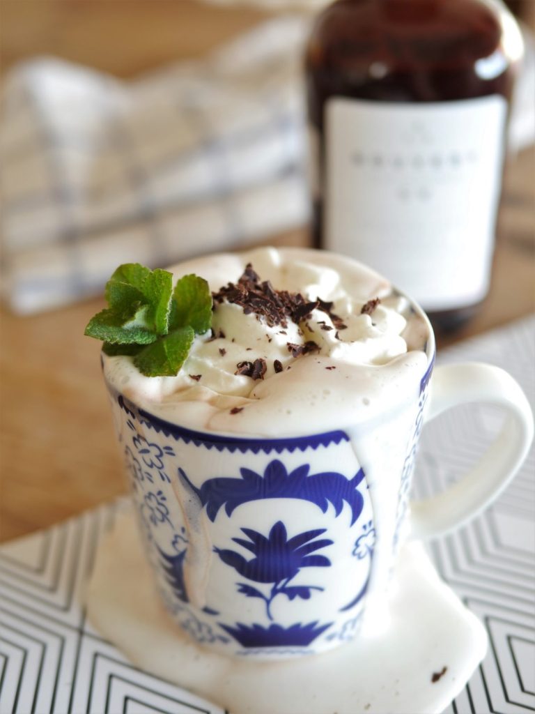 Boozy Hot chocolate with whipped cream and chocolatey liqueur bottle