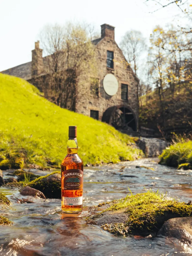 Tamnavulin distillery and bottle by a river