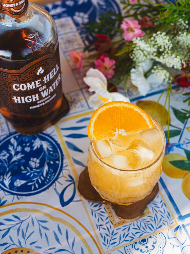 Honey and Orange rum bottle and a glass of rum punch