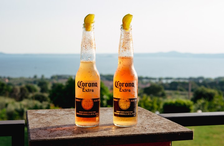 Tequila cocktail in a corona beer bottle with a lake view